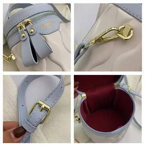 Detailed view of the wave texture, gold zippers, and adjustable strap on the bucket bag