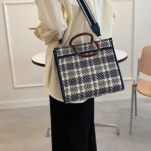 Detail view of the vintage blue tweed check tote bag with resin handle and striped strap