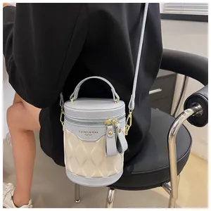 Detail of blue and cream color-block bucket bag with quilted texture and metal zippers