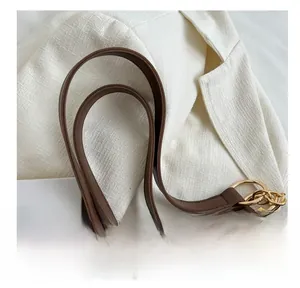 Dettaglio del cinturino in pelle marrone con anelli in metallo dorato per borsa tote