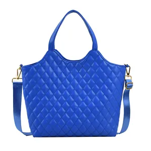 Royal blue quilted tote bag with golden hardware and adjustable crossbody strap