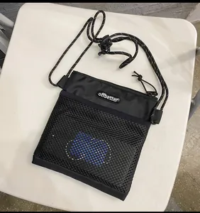 Close-up of black nylon crossbody phone bag with mesh pocket and offbetter logo