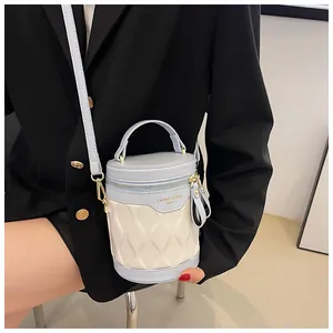 Detail of blue and white contrast bucket bag with quilted waves and gold hardware