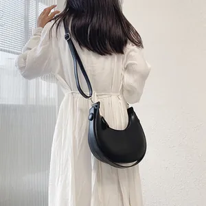 Minimalist black crescent moon shoulder bag in smooth PU leather with adjustable strap