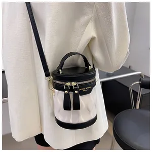 Detail shot of black and white bucket bag with textured wave pattern and gold metal zippers