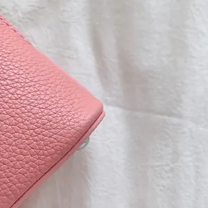 Dettaglio pelle rosa a grana fine con cuciture precise e bordi arrotondati lisci