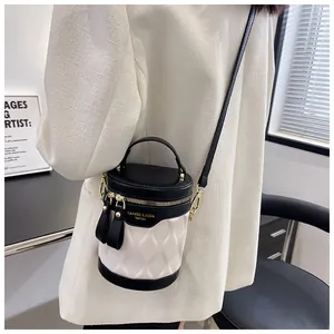 Close-up of contrast bucket bag featuring quilted white leather and golden zip details