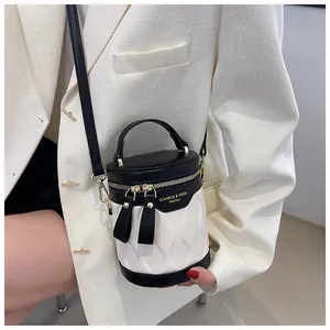 Detail of a contrast black and white bucket bag with wave texture and gold logo