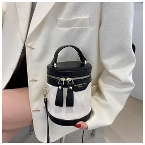 Detailed shot of contrast black and white bucket bag with wavy quilted texture and gold logo