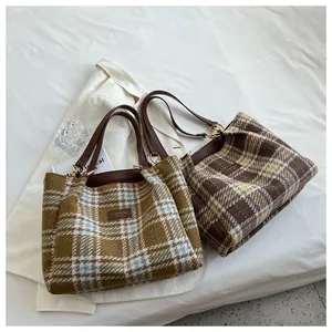 Dettaglio della borsa tote vintage a quadri con trama in lana e manici in pelle
