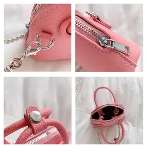 Dettaglio mini borsa a conchiglia rosa con trama a grana litchi e hardware argento