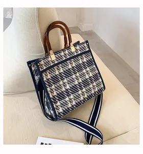 Detail of tweed tote bag featuring vintage resin bamboo handles and striped strap