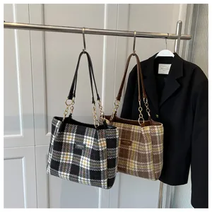 Dettaglio di borse tote in tweed a quadri con catena dorata e manici in pelle