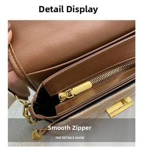 Detail view of smooth golden zipper and brown lychee grain leather on crossbody bag