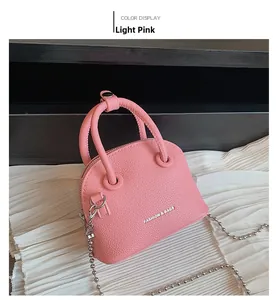 Dettaglio della mini borsa a conchiglia rosa chiaro con trama litchi e catena