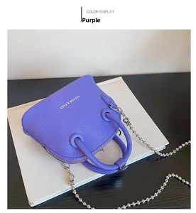 Macro della mini borsa a conchiglia in pelle viola con trama litchi e catena