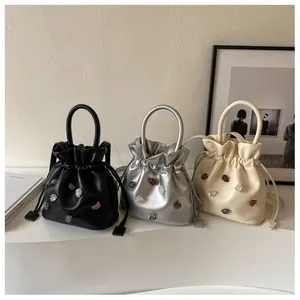 Drei Kordelzug-Beuteltaschen in Schwarz, Silber und Beige mit farbigen Edelsteinakzenten