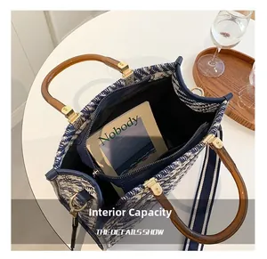 Top view of tote bag interior with blue woven texture, acrylic handle and zip pocket
