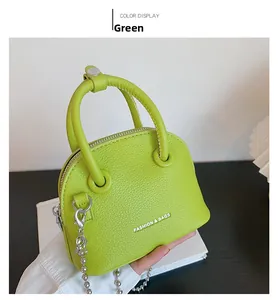 Dettaglio mini borsa a conchiglia verde con trama litchi e catena metallica argento