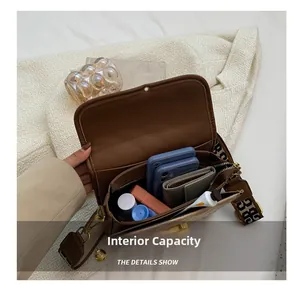 Internal capacity of brown crossbody bag showing space for phones and cosmetics