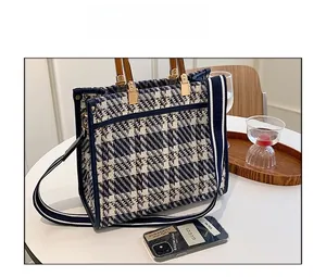 Detail of blue and white tweed tote bag with bamboo handle and striped fabric strap