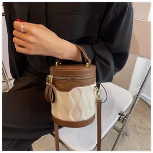 Detail view of contrast bucket bag featuring wavy embossed texture and gold hardware