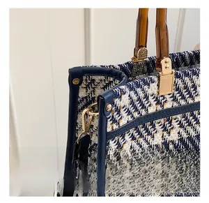 Detail of woven fabric texture, tortoiseshell resin handle and gold metal hardware hooks