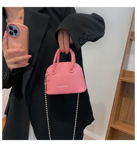 Mini borsa a conchiglia rosa con trama litchi, catena a sfere e logo fashion