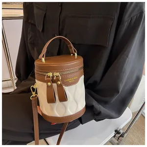 Detail of color-block bucket bag showing wavy quilted texture and gold-tone zippers