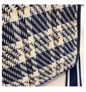 Close-up of blue and yellow houndstooth tweed texture and woven strap detail on tote bag
