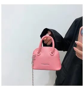 Dettaglio mini borsa a conchiglia rosa con trama litchi e tracolla a catena