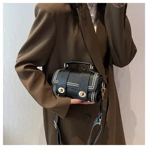 Detail of black mini crossbody bag with metal twist locks and floral fabric strap