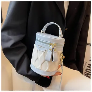 Detail of light blue and beige bucket bag with wave quilting and gold zipper