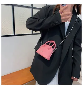 Mini borsa a conchiglia rosa con trama litchi, catena a sfere e borchie sul fondo