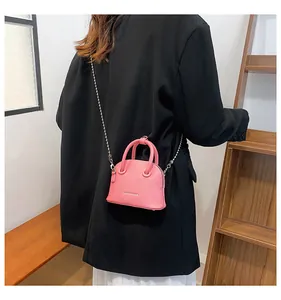 Mini borsa a conchiglia rosa in pelle a grana con catena argentata e lettering