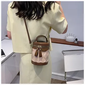 Detail of color-block bucket bag with quilted texture and double metal zippers