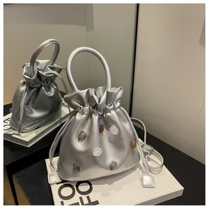 Detailaufnahme der silbernen Strass-Beuteltasche mit Kordelzug und elegantem Griff