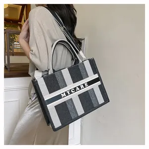 Borsa tote a righe bianche e nere con tracolla larga regolabile e dettaglio del logo