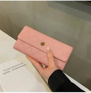 Dettaglio del portafoglio rosa trapuntato con chiusura a fiore in oro antico