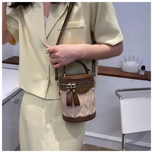 Detail view of a two-tone bucket bag with wave texture and leather shoulder strap