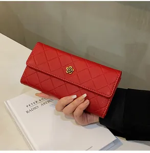 Dettaglio del portafoglio lungo in pelle rossa trapuntata con fibbia a fiore dorato