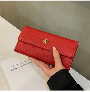 Dettaglio del portafoglio lungo rosso trapuntato con fibbia a fiore dorato e grana fine