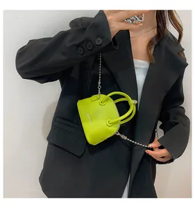 Dettaglio mini borsa verde lime in pelle texture litchi con catena a sfere d'argento