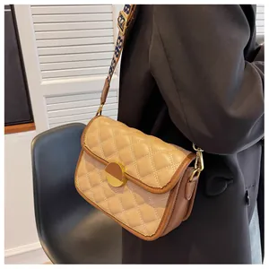 Detail of khaki quilted crossbody bag with golden buckle and jacquard shoulder strap