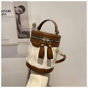 Detail of a brown and white cylinder bucket bag with embossed texture and metal zipper