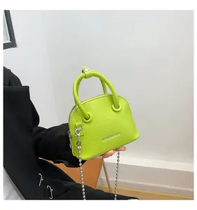 Dettaglio mini borsa a conchiglia verde lime con trama litchi e catena d'argento
