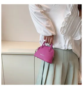 Dettaglio mini borsa a conchiglia rosso rosa con trama litchi e catena a sfere argento