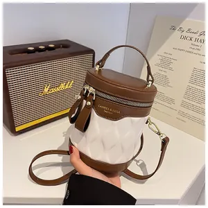 Close-up of contrast color mini bucket bag with embossed pattern and gold hardware