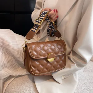 Brown quilted crossbody bag with adjustable wide printed strap and gold buckle