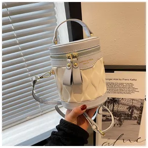 Detail of blue and white bucket bag with diamond texture and gold hardware details